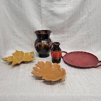 Photo showing the full group of five pottery items including two leaf-shaped trays, two vases, and one round tray.