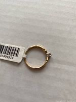 Top view of 10Kt yellow gold ring with attached tag showing condition and size.