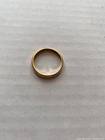 Top view of the plain 14Kt yellow gold wedding band ring, showing its smooth round shape and polished finish.