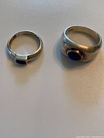 Photo of two sterling silver rings with blue stones, showing size and details of stones and bands.