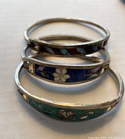 Three silver inlay bangle bracelets stacked, showing various colorful inlay patterns