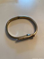 Sterling silver buckle style adjustable bracelet laid flat showing the full design and buckle face.