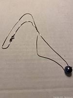 Silver chain necklace laid out showing the full length and the clasp.