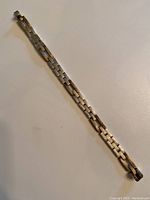 Full length view of the heavy link silver bracelet laid out flat on a surface, showing overall length and clasp.