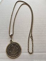 Photo showing full 24 inch silver rope chain with attached large round silver medallion pendant featuring Aztec sundial design.