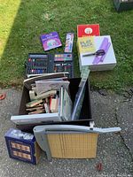 Photo showing the arts and crafts box with various supplies including paint sets, brushes, canvases, paper trimmer, and other tools.