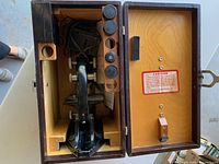 Microscope positioned inside the wooden case with compartments visible