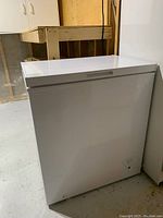 Front and angled view of white chest freezer showing general condition and placement.