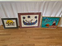 Three framed art pieces arranged on floor showing overall lot contents