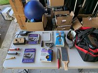 Table with multiple wood carving accessories and electronic soldering irons neatly laid out including a carrying bag.