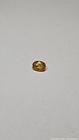 Oval cut bright yellow sapphire gemstone shown from above on white background.