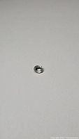 Oval loose Ceylon sapphire gemstone placed on a neutral surface, showing clarity and luster under diffuse lighting.