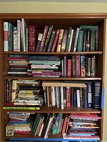Full bookshelf showing four shelves filled with mixed books
