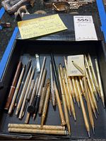 Overall view of tray showing assortment of pens and pencils