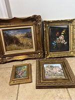 All four framed paintings arranged on floor, showing size and condition