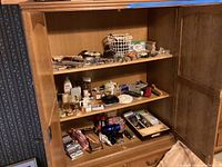 Wooden shelves with a wide variety of personal care products including perfumes, nail care, and hair styling tools.