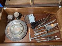 Overview of lot showing silver-tone mugs, trays, glass coasters and assorted cutlery