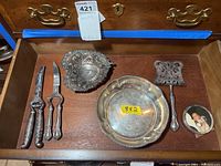 Drawer view showing all six items: two pairs of shears/scissors, pierced filigree bowl, lobed rim bowl, pierced spatula server, round photo frame