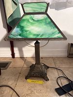 Front and side view of the green slag glass shade lamp showing lamp shade and pull chain with metal base.