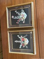 Two framed vintage sea shell arrangements displayed one on top of the other showing overall appearance.