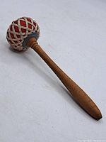 Full view of the wooden Tibetan singing bowl mallet showing the tapered handle and padded end.