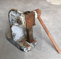 Side angled view of Arbor Press showing handle with surface rust and paint chipping on frame