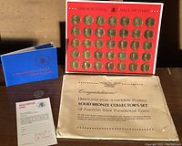 Complete set of 35 Franklin Mint solid bronze Presidential coins displayed mounted on red board labeled 'Presidential Hall of Fame' with original packaging, registration card, and booklet.