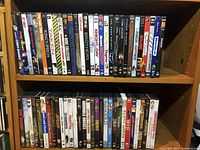 Photo of DVDs on shelf showing titles including Taken, The King's Speech, Night and Day, The Bone Collector, Lord of the Rings, Gremlins, and others.