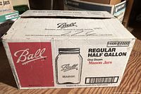 Photo of full case box labeled Ball Regular Half Gallon Mason Jars, showing packaging and brand details.