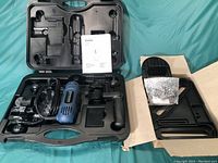 Full case opened to display spin saw, power cord, accessories, and carrying case compartments on a fabric surface.