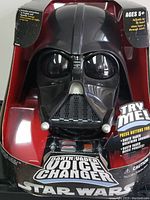 Front view of Darth Vader voice changer mask in original packaging, showing mask details and Try Me button instructions.