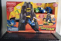 Full box front showing the Fisher Price Geo Trax Batcave RC Set with Batman branding, including vehicles and play features.