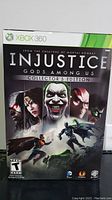 Front view of large collector's edition box for Injustice Gods Among Us Xbox 360 showing main character artwork and logos.
