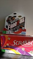 Image showing one Yahtzee Free For All game and one Scrabble game, both new in original packaging.