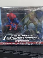 Front view of sealed limited edition Blu-ray gift set showing Spider-Man and The Lizard figurines inside original packaging.