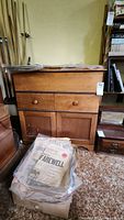 Front view of antique wooden dry sink cabinet with drawer and doors closed, showing some surface wear.