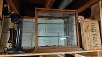 Overview showing candlestick phone on left, glass display cabinet center, wooden crate right