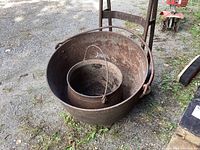 Both cauldrons nested inside each other on gravel ground