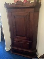 Front elevation view of corner cupboard showing door, drawer, and gallery