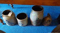 Four stoneware pieces on blue carpet under table