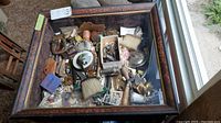 Overhead view of open wood chest filled with assorted vintage items