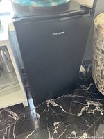 Closed black Hisense mini fridge showing external appearance.