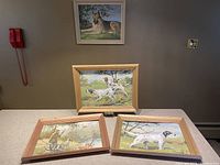Four framed paint by numbers dog paintings shown together providing an overview of the lot.