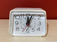 Front view of the Ingraham electric alarm clock showing the clock face with black numerals and hands.