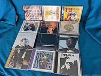 Photo showing 12 blues music CDs arranged on a blue fabric background, including Buddy Guy, Jimi Hendrix Experience, Ike & Tina Turner, and others.