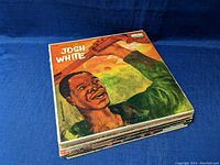 Stack of vinyl record albums with Josh White front album showing artistic illustrated cover