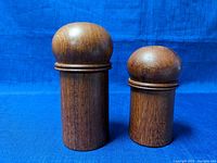 Pair of wooden salt and pepper shakers from Dansk Designs Denmark, showing natural wood grain and smooth rounded tops.