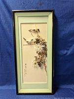 Full view of framed Chinese wall art with silk flowers and birds, showing overall condition and framing.