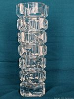 Full front view of tall crystal vase showing deep cut geometric patterns and thick base.