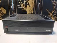 Front view on decorative backdrop showing power button, indicator LEDs and model branding